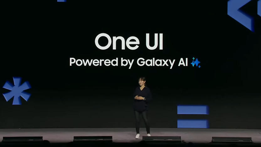 A Samsung executive onstage in front of a large display, reading "One UI: Powered by Galaxy AI."