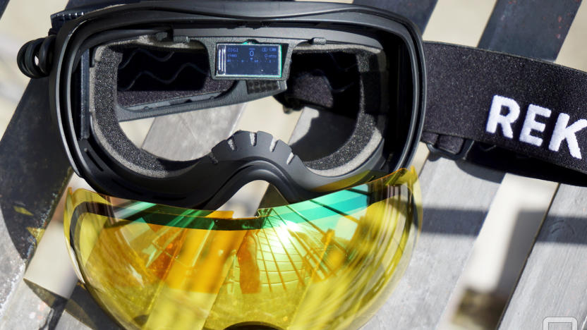 Ski Goggles with yellow lenses that have been removes and a small display in the middle of the frames.                               