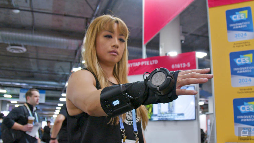 A woman wearing the GyroGlove at the CES 2024, holding her hand out. 