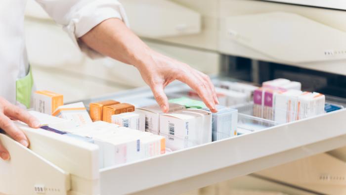 Close up of pharmacist hand taking meds from drawer