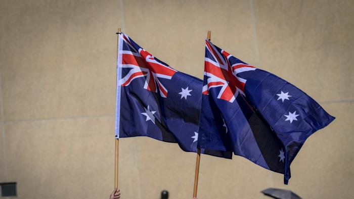 CANBERRA, AUSTRALIA - 2024/10/21: Royals' supporters are seen holding two Australian national flags. King Charles and Queen Camilla received a ceremonial welcome from the Australian troops and met with members of the public at the Parliament House forecourt in Canberra. Their Majesties will be in Australia from 18 to 23 October 2024, marking King Charles's first visit to Australia as Sovereign. (Photo by George Chan/SOPA Images/LightRocket via Getty Images)