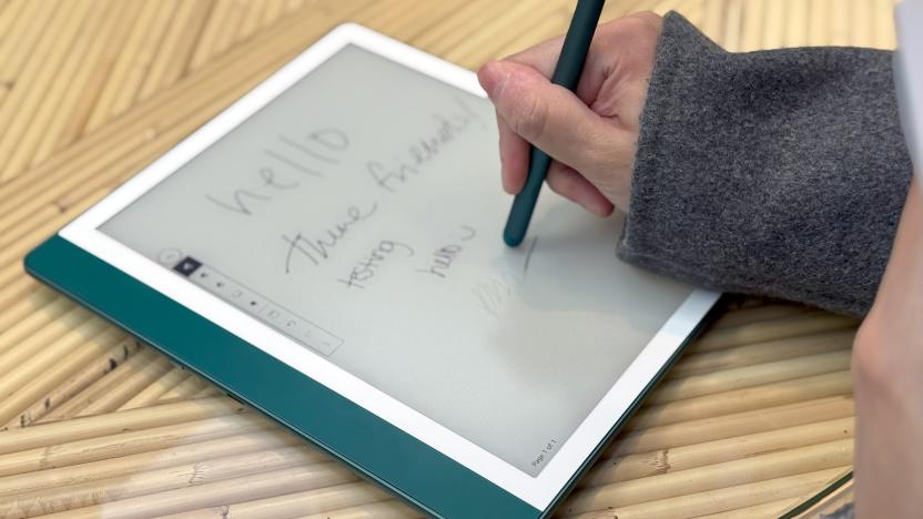 The Amazon Kindle Scribe held in mid-air, with a skylight and buildings in the background.